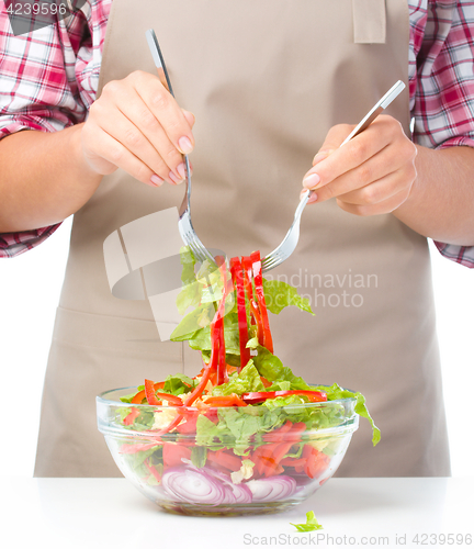 Image of Cook is mixing salad