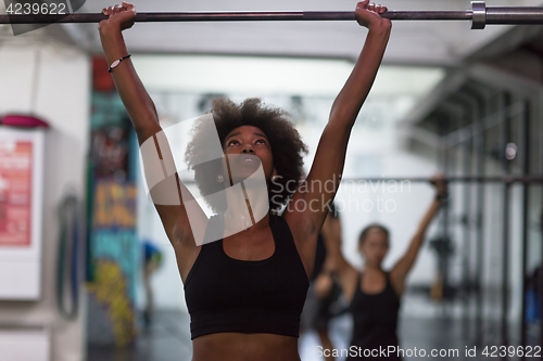 Image of black woman lifting empty bar