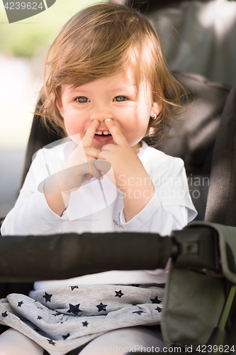 Image of baby girl sitting in the pram