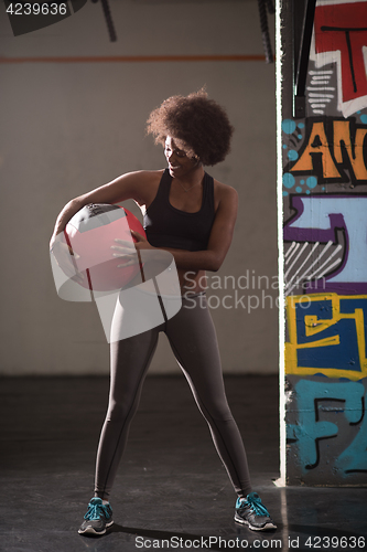 Image of black woman carrying crossfit ball