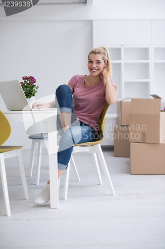 Image of Young woman moving in a new home