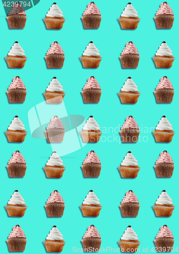 Image of Colorful pattern made of cupcakes on blue background.