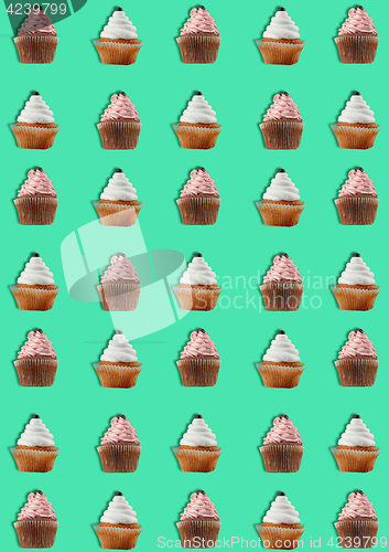 Image of Colorful pattern made of cupcakes on green background.