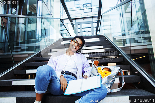 Image of young cute indian girl at university building sitting on stairs 