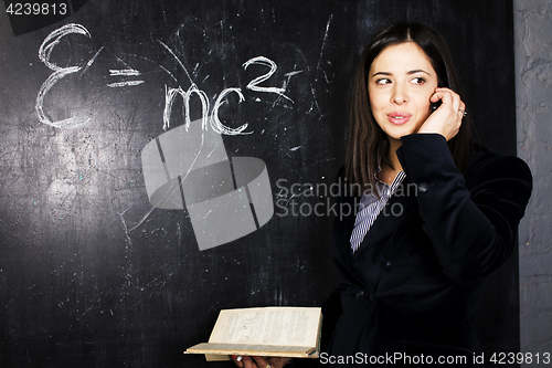 Image of portrait of happy cute student in classroom at blackboard back t
