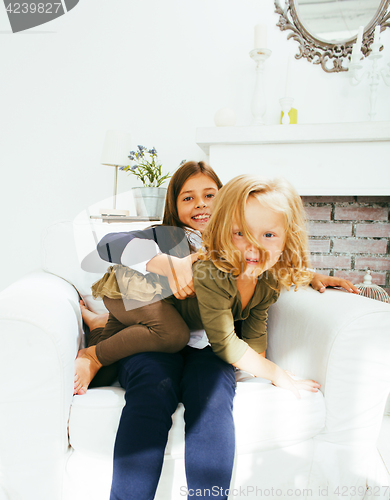 Image of two cute sisters at home playing, little girl in house interior 