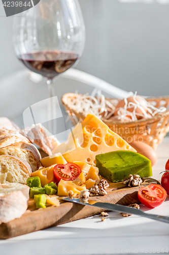 Image of Wine, baguette and cheese on wooden background