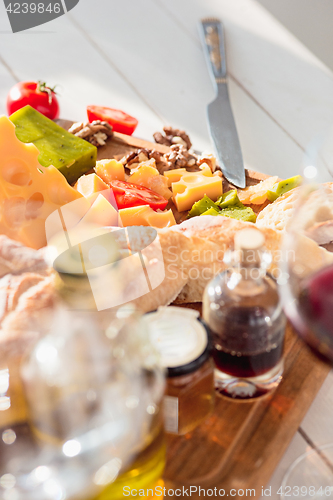 Image of Wine, baguette and cheese on wooden background