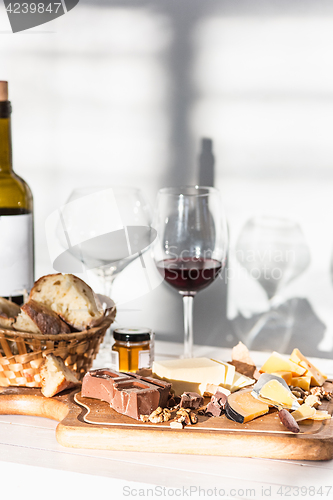 Image of Wine, baguette and cheese on wooden background