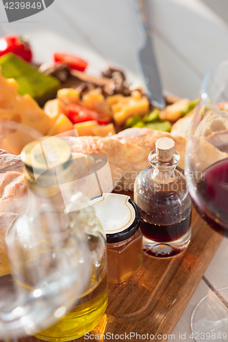 Image of Wine, baguette and cheese on wooden background