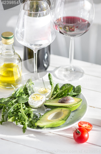 Image of Wine, Tomatoes and greenery wooden background