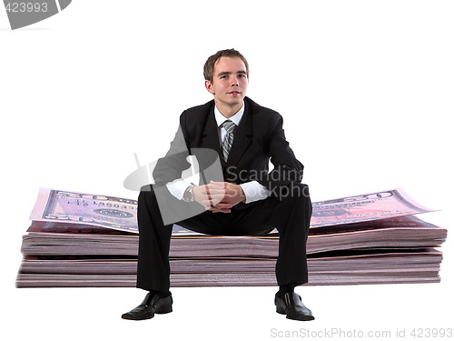 Image of Businessman on dollar stack