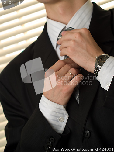 Image of Young buisnessman ties necktie