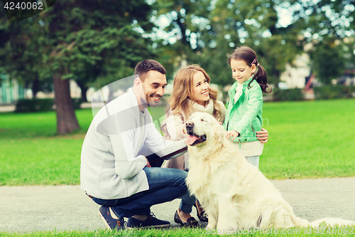 Image of happy family with labrador retriever dog in park