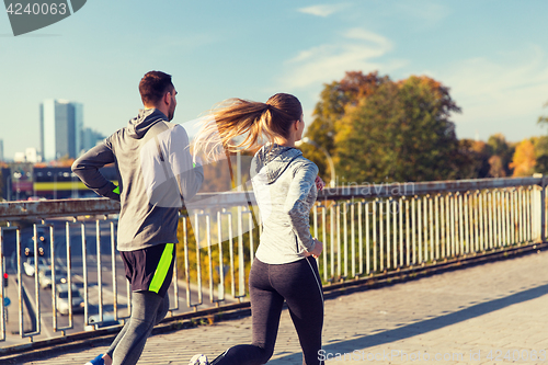 Image of happy couple running outdoors