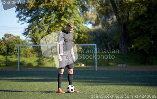 Image of soccer player playing with ball on football field