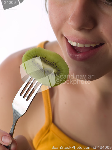 Image of Teen eats kiwi