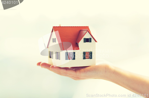 Image of close up of hands holding house or home model