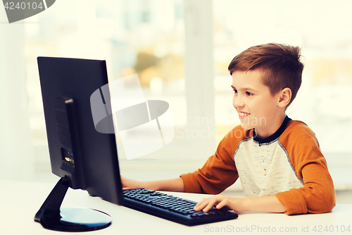 Image of smiling boy with computer at home
