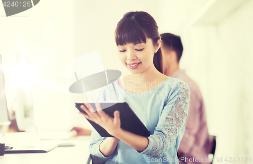Image of happy creative female office worker with tablet pc