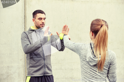 Image of woman with trainer working out self defense strike