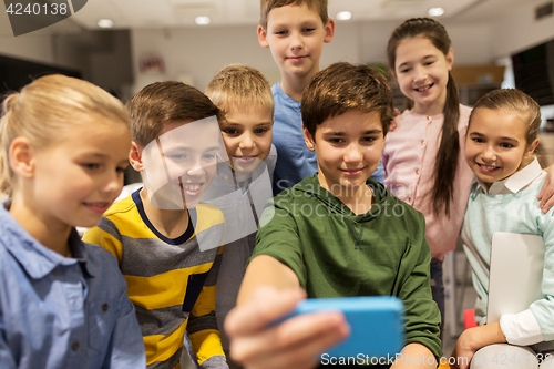 Image of group of school kids taking selfie with smartphone