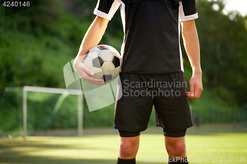 Image of soccer player with ball on football field