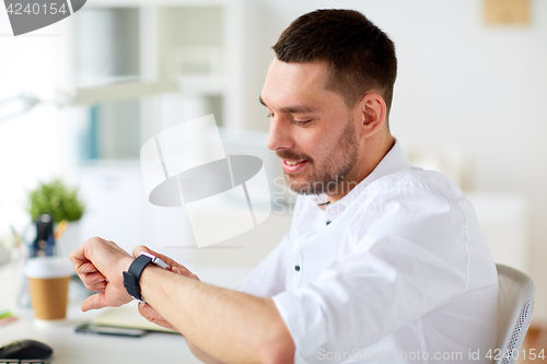 Image of close up of businessman with smartwatch at office