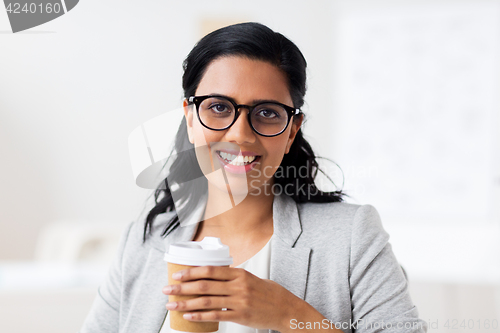 Image of businesswoman with coffee in paper cup at office