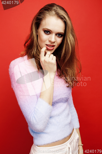 Image of young pretty emitonal posing teenage girl on bright red background, happy smiling lifestyle people concept 