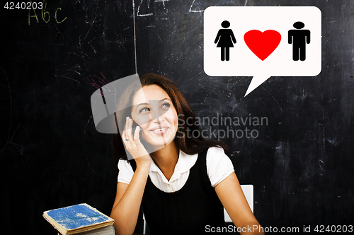 Image of portrait of happy cute student in classroom at blackboard back t