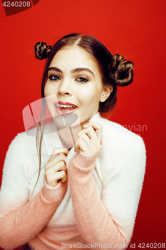 Image of young pretty emitonal posing teenage girl on bright red background, happy smiling lifestyle people concept 