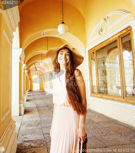 Image of young pretty smiling woman in hat with bags on shopping at store