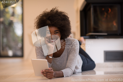 Image of black women using tablet computer on the floor