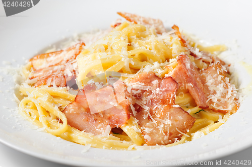 Image of tagliatelli carbanara italian cuisine on plate rustic kitchen table background