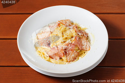 Image of tagliatelli carbanara italian cuisine on plate rustic kitchen table background