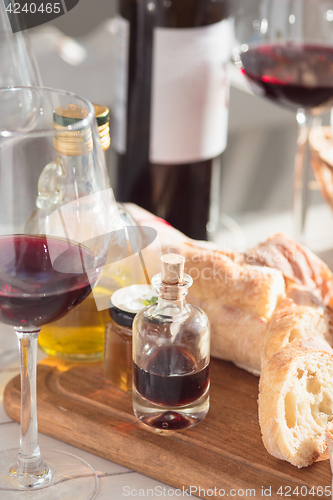 Image of Wine, baguette and cheese on wooden background