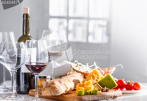 Image of Wine, baguette and cheese on wooden background