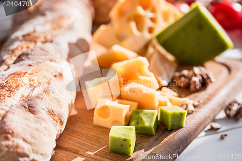 Image of The baguette and cheese on wooden background