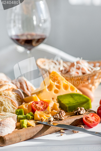 Image of Wine, baguette and cheese on wooden background