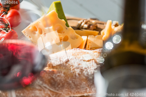 Image of Wine, baguette and cheese on wooden background