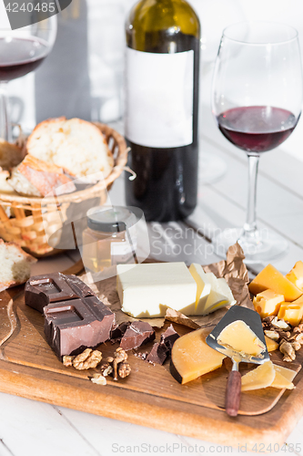 Image of Wine, baguette and cheese on wooden background