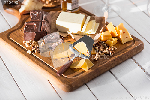 Image of The different kind of cheese and walnuts on wooden background