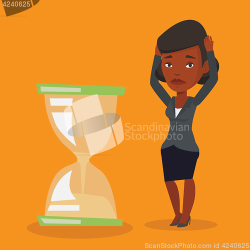 Image of Desperate business woman looking at hourglass.