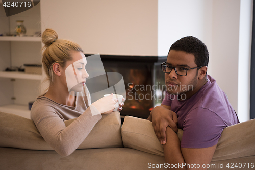 Image of Young multiethnic couple  in front of fireplace