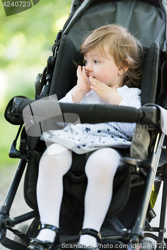 Image of baby girl sitting in the pram