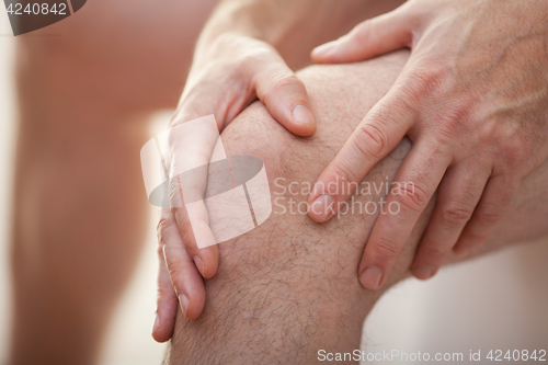 Image of Man holding his knee