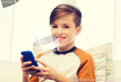 Image of boy with smartphone texting or playing at home