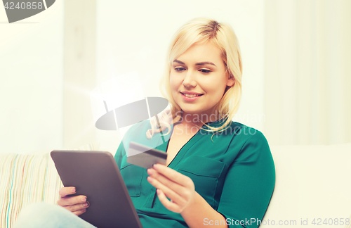 Image of happy woman with tablet pc and credit card