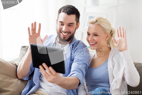 Image of couple with tablet pc having video chat at home